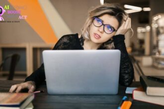 Tired solopreneur feeling burnout while working on laptop in coworking space
